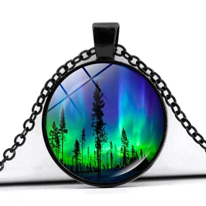 Détail macro du pendentif en verre aurore boréale avec silhouette de forêt et chaîne noire