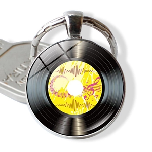 Macro di un portachiavi a disco in vinile retrò con note musicali su sfondo bianco