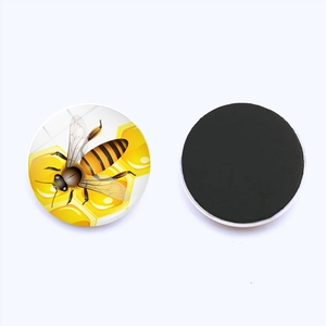 Detail of round bee fridge magnet showing the cartoon pattern and black soft magnetic back