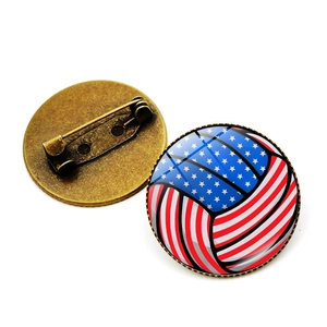 Detail view of American flag volleyball brooch with bronze metal base and safety pin