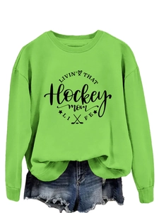 Bright green hockey mom sweatshirt paired with distressed denim shorts on white background