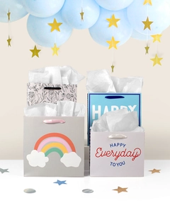 Detail of assorted gift bags with rainbow patterns and silk handles on a white surface