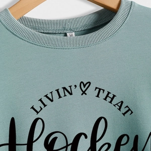 Light blue crewneck sweatshirt featuring Livin That Hockey Mom Life graphic print