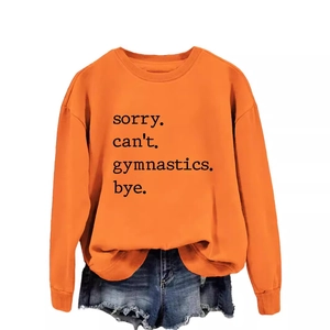 Orange long sleeve sweatshirt with 'sorry can't gymnastics bye' print and denim shorts