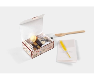 Close-up of floral pastry box with assorted mini desserts and elegant gift card decoration