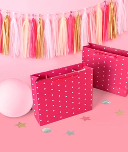 Detail of rose pink polka dot gift bag with matching silk ribbon handles for parties
