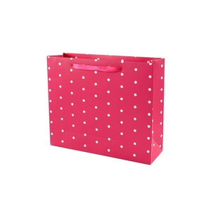 Pink polka dot gift paper bag with ribbon handles for festive packaging needs