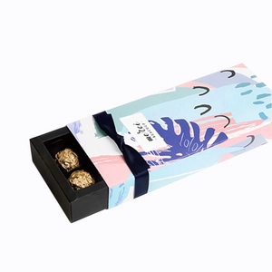 Rectangle chocolate gift box with colorful abstract cover and navy blue ribbon tie