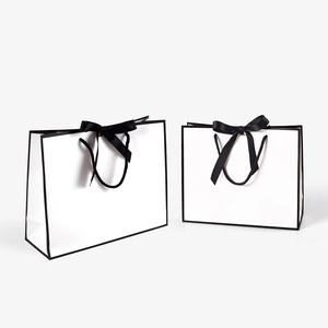 Minimalist white gift bags with black borders and elegant black satin ribbon handles