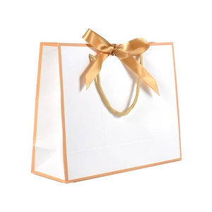 Elegant white paper gift bag with champagne gold borders and a satin ribbon bow