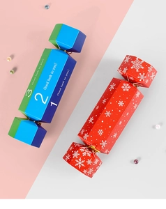Macro view of candy-shaped wedding gift boxes with gold ribbons and snowflake patterns
