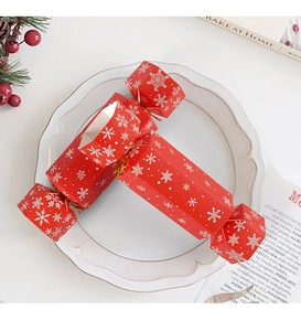 Macro detail of red Christmas candy gift box with white snowflakes on white plate