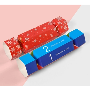 Close-up of candy-shaped paper gift boxes with snowflake patterns and Good Luck text