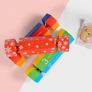 Candy cracker gift boxes with red snowflake and colorful gradient designs on pink background