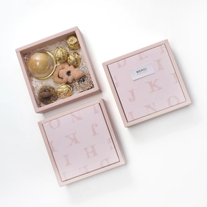 Detailed view of pink gift boxes with elegant lettering and sweet pastries inside
