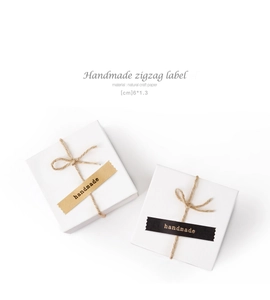Primer plano de etiquetas de 6x1.3cm en papel kraft natural con texto handmade en regalo