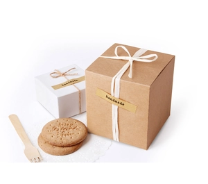 Detalle de etiquetas hechas a mano en cajas de regalo cuadradas con cuerdas naturales