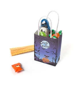 Close-up of Halloween trick or treat paper gift bag with pumpkin and candy contents