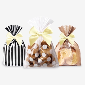 Detailed view of striped and polka dot gift bags with yellow ribbon bows for cookies