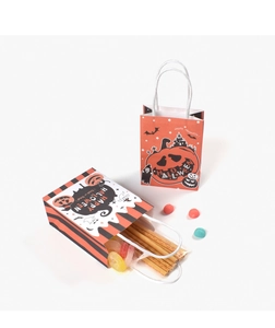 Close-up of Halloween paper gift bags with orange pumpkin patterns and candy inside