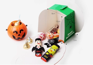 Close-up of green spiderweb Halloween gift box with vampire and Frankenstein cartoon sleeves