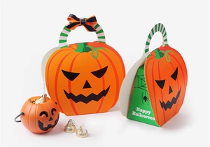 Macro shot of Halloween pumpkin gift boxes with Happy Halloween print and green handles