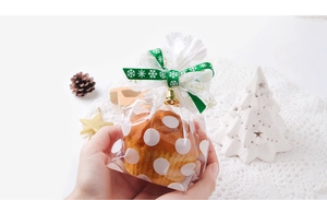 Sachet cadeau à pois avec ruban vert à flocons et petite cloche dorée décorative