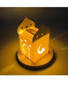 Dettaglio macro scatola regalo intagliata con stelle e lune e luce LED su base legno