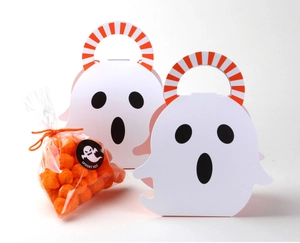 Close-up of white ghost shaped gift boxes with orange striped handles and spooky snacks