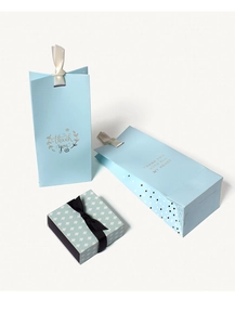 Detail of light blue gift bags with gold thank you text and floral patterned gift box