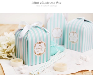 Detail of mint green striped gift box with white ribbon bow and eco-friendly coating