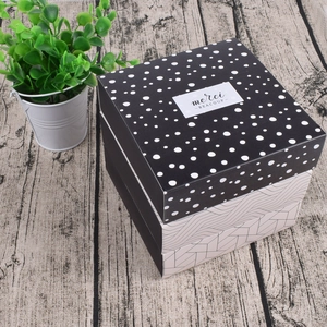 Driedelige stapel minimalistische vierkante geschenkdozen met stippatroon en merci-label
