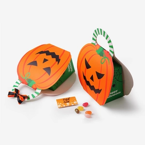 Creative pumpkin Halloween gift box with orange Jack-o'-lantern face and ribbon handle
