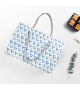 Detail of paper gift bag with pixelated flower patterns and silver twist handles