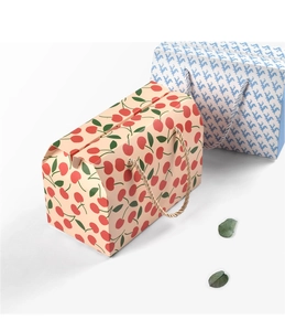 Detail view of foldable paper cake boxes with cherry and vintage patterns and handles