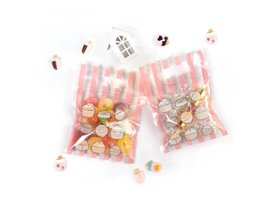 Detalle de bolsas de regalo a rayas rosas con estampados de postres y asas
