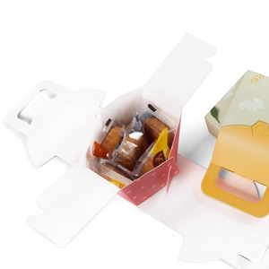 Pink polka dot folding cookie box with a yellow honeycomb handle for festive candy packaging