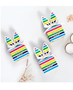 Macro detail of rainbow striped bunny ear gift boxes with white satin ribbons and text
