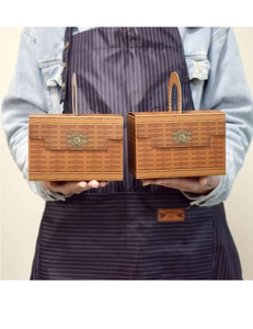 Detail of woven texture gift box with vintage bronze clasp and arched handle