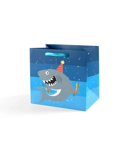Close-up of cute shark gift bag with Happy Birthday text and blue silk handles