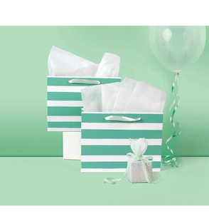 Detail of mint green striped gift bags with silk handles and matching silver polka dot box