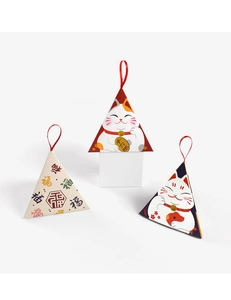 Macro shot of triangular gift boxes with lucky cat and fortune motifs with red ribbons