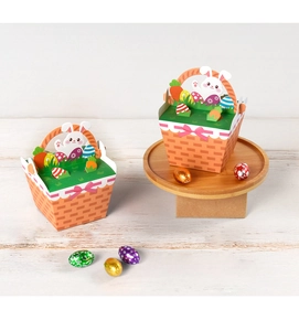 Detail of Easter candy gift boxes with 3D bunny and egg toppers on wood surface