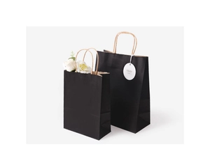 Detail of matte black kraft paper gift bags with sturdy wooden color handles and hang tag
