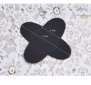 Detail view of a black 9.5x3.5cm fabric elbow patch with precise stitching on lace background