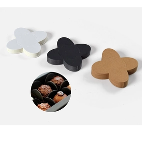 Detail of clover shaped paper chocolate liners in black, white and kraft brown colors