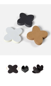Detailed view of foldable clover-shaped chocolate paper holders in black, white, and brown