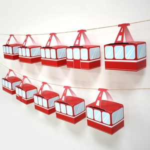 Red cable car party favor boxes hanging on a jute rope for birthday event decoration