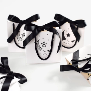 White mini gift bag with black satin bow and moon star pattern for stylish packaging