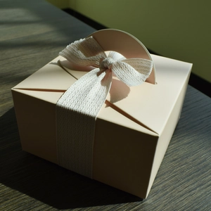 Elegante scatola regalo quadrata rosa crema con manico in nastro bianco e oro
